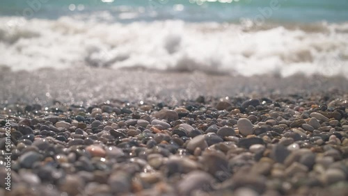 Sea waves on a pebble beach, 4k real-time stock video, selective focus, beautiful close-up shots of sea waves washing the beach