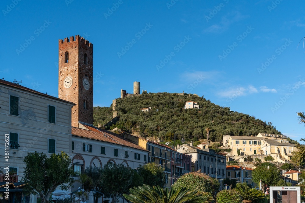 Low angle shot of a historic tower and buildings in Noli along the Via Aurelia road, Liguria, Italy