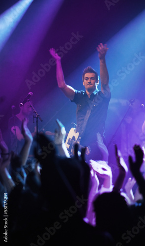 Getting the fans pumped. a performer interacting with the crowd at a concert. © Julie Francoeur/peopleimages.com