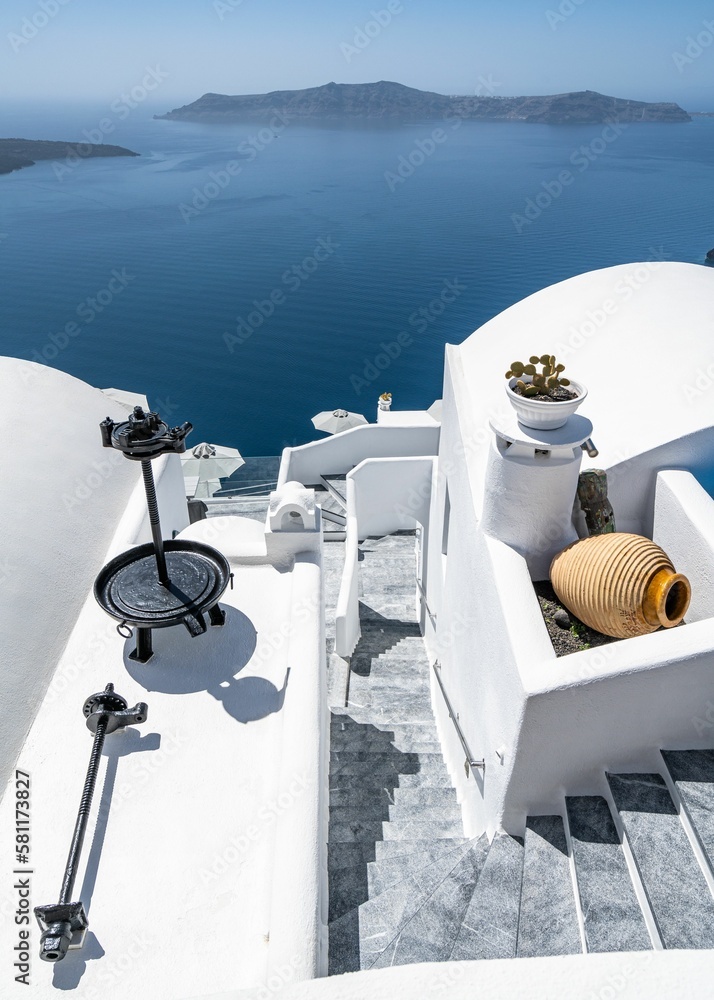 Typical white house in the Cycladic architecture of Greece overseeing a scenic blue seascape