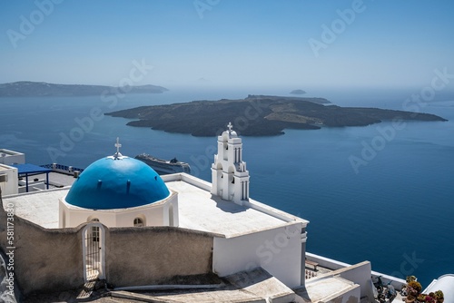 Fototapeta Naklejka Na Ścianę i Meble -  Three Bells of Fira in Santorini, with its characteristic blue dome located above the cliffs, Greece