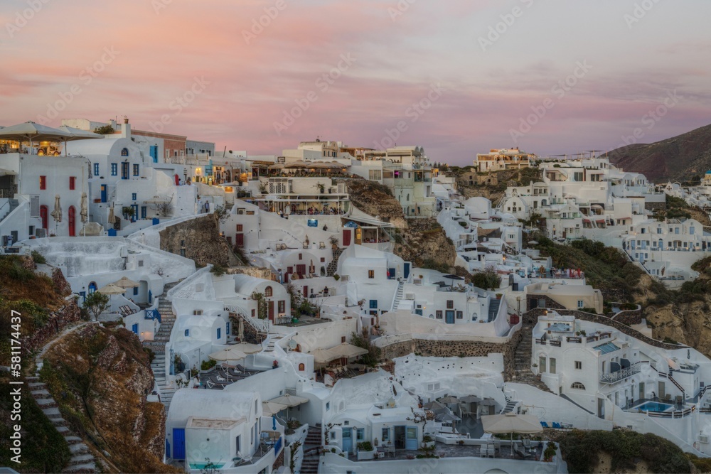 Scenic sunset of Oia village in Santorini with its typical white houses, Greece.
