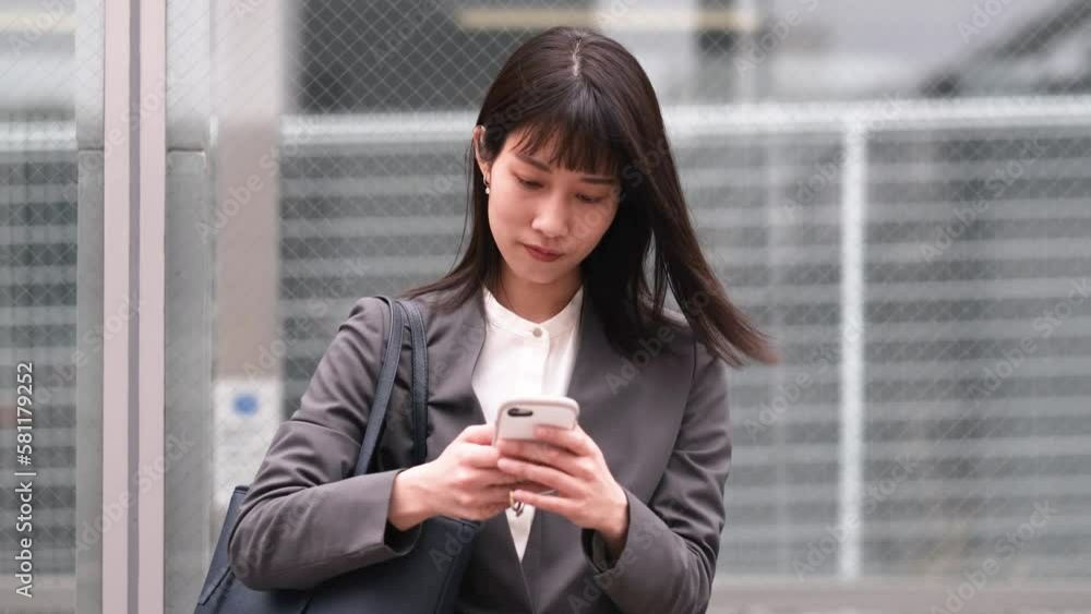 携帯電話を見るビジネスウーマン 携帯電話を見るビジネスウーマン