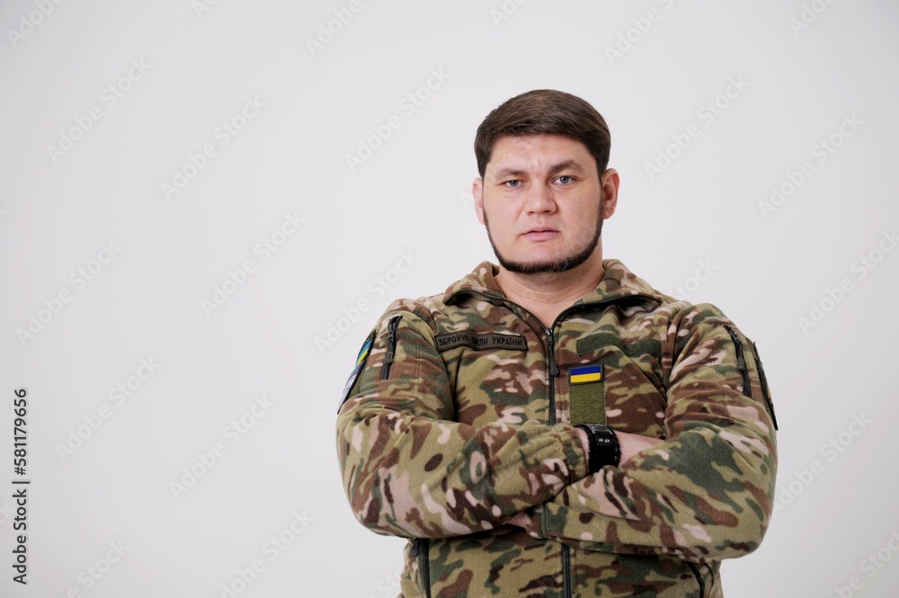 Ukrainian soldier wearing military uniform with flag and chevron depicting trident Ukrainian emblem and national symbol Midsection Of Army Soldier Standing Armed Forces of Ukraine. Ukrainian soldier