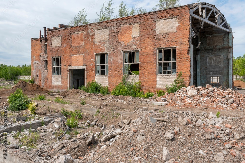 Old dilapidated emergency building of red brick production workshop against of summer blue sky