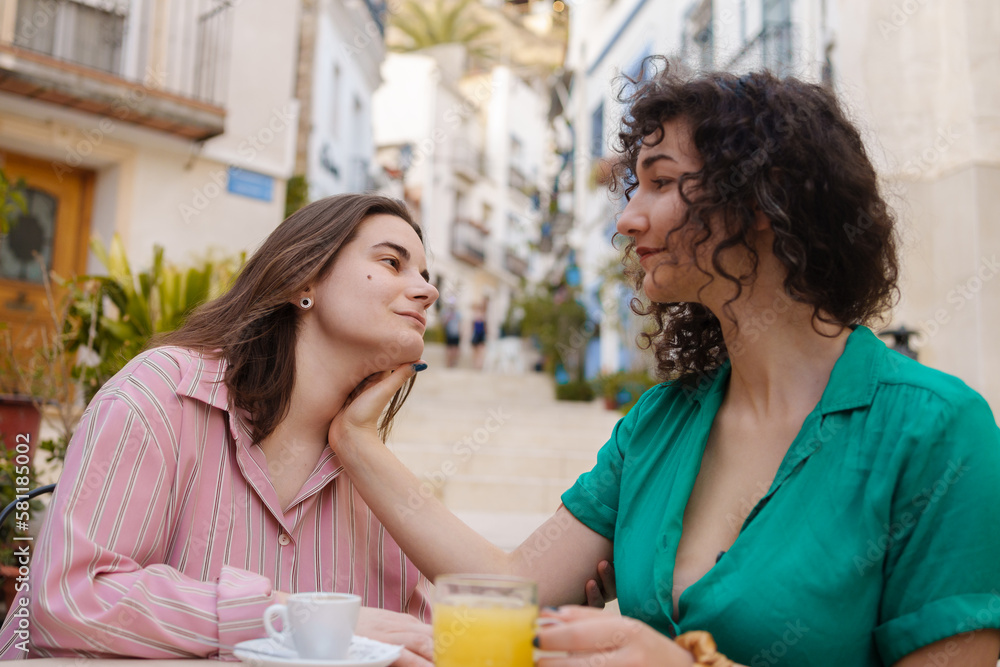 two enamored lesbian girls drink coffee happily on gay pride day two enamored lesbian girls drink coffee happily on gay pride day