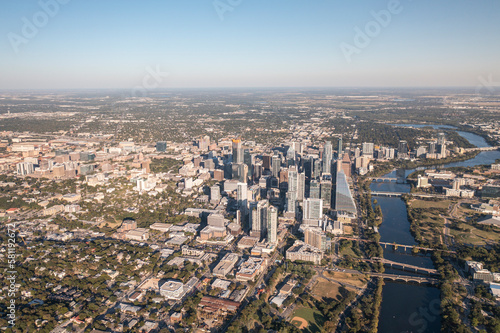 Fototapeta Naklejka Na Ścianę i Meble -  Austin, Texas USA - October 1 2022: Overhead view of downtown Austin, Texas skyline during golden hour sunset with Lady Bird Lake and Colorado River and surrounding landscape 