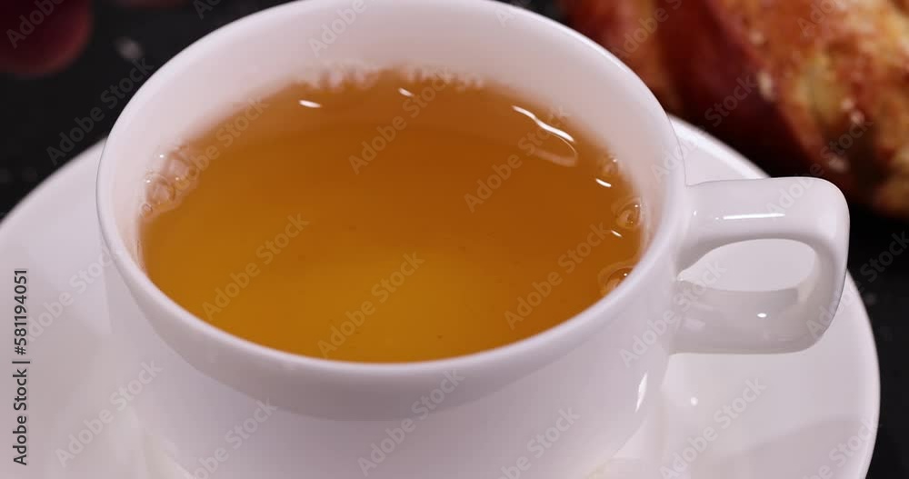 a wheat bun with filling and a mug of hot green tea,Preparation of green tea for a sweet dessert a wheat bun with filling and a mug of hot green tea,Preparation of green tea for a sweet dessert