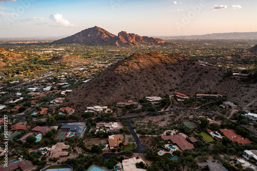 Aerial view during sunset of Paradise Valley and Scottsdale, Arizona with Camelback Mountain and surrounding Phoenix landscape and neighborhoods