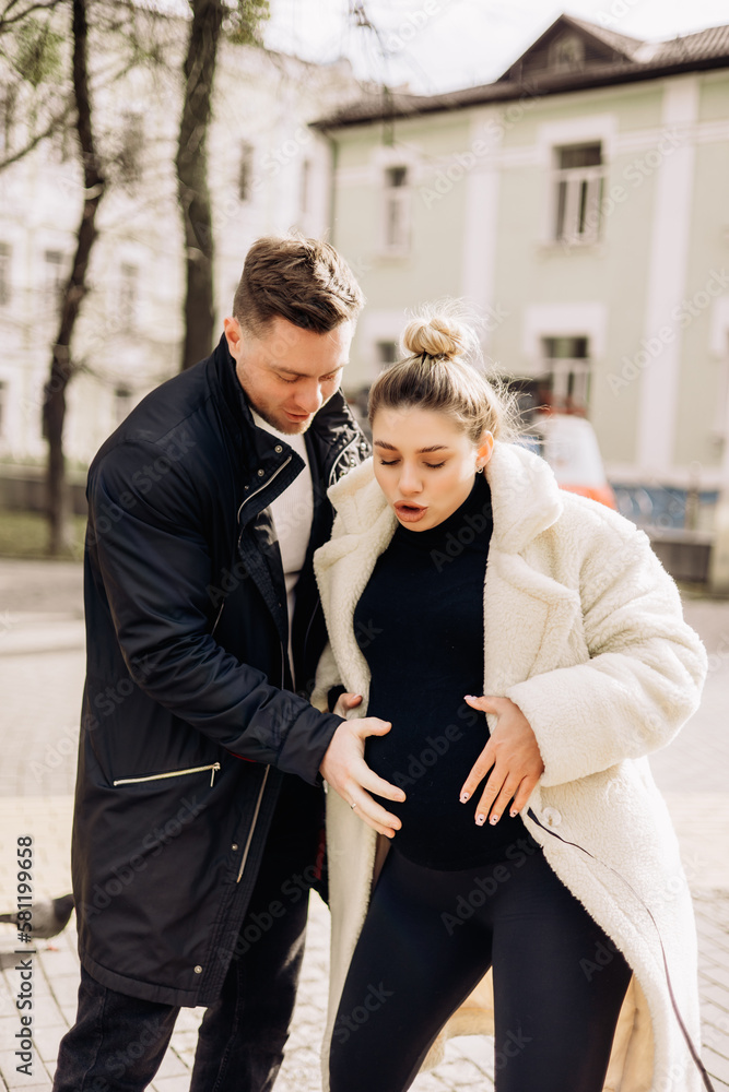 A young couple in love is walking on the street and enjoying the fresh air. Happy married couple. A stylish couple, a man and a woman A young couple in love is walking on the street and enjoying the fresh air. Happy married couple. A stylish couple, a man and a woman