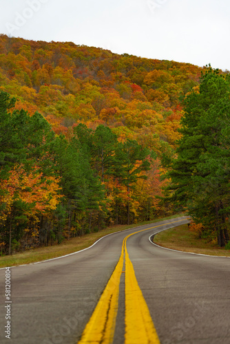 Rural road in Southeastern Oklahoma along Talimena Scenic Route during autumn season with fall foliage landscape