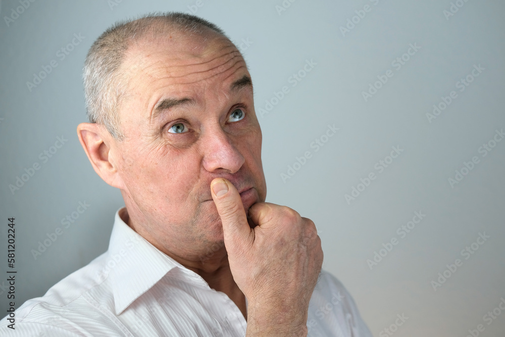 close-up of mature charismatic man, senior 60 years surprised, puzzled, shocked by news, event, bright facial expressions, overhang, concept human health, mood, human stress resistance