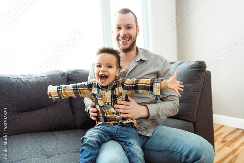 Father And Son having fun On sofa Together