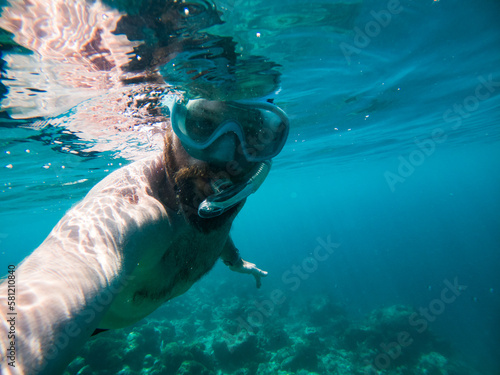 man snorkeling in crystal clear tropical sea