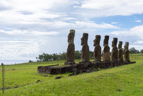 Back view of seven moai statues at Ahu Akivi, the only ahu with moai statues that are facing the Pacific Ocean on Easter Island (Rapa Nui),  Chile. photo