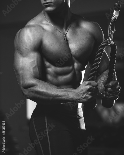 Muscular guy, fitness model, bodybuilder posing after training in the gym