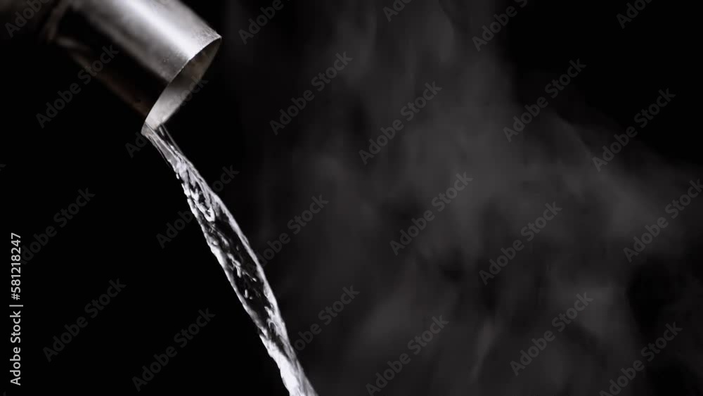 Jet of Boiling Water from a Kettle Pours on the Background of Clubs White Steam. Evaporation of steam on a black background. A falling jet of boiling water from a teapot. Whirlpool, clouds. soft fog. Jet of Boiling Water from a Kettle Pours on the Background of Clubs White Steam. Evaporation of steam on a black background. A falling jet of boiling water from a teapot. Whirlpool, clouds. soft fog.