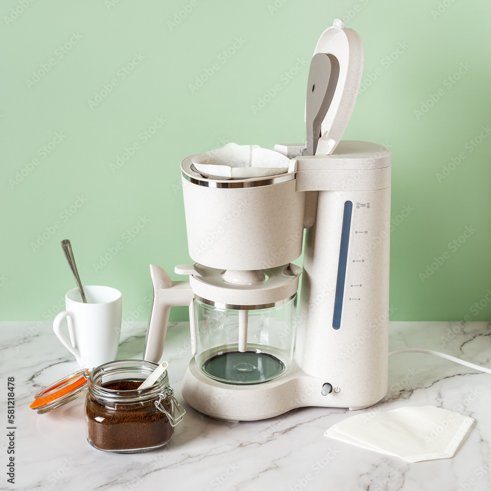 Automatic drip coffee machine and jar of ground coffee. Preparing ...