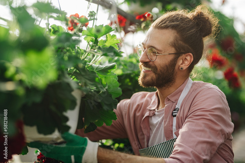 Man gardener working in a greenhouse photo