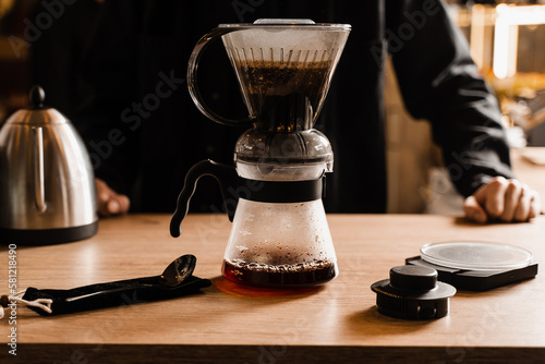 Pouring coffee in pot from clever dripper with pour over filter in cafe. Alternative method of brewing coffee in clever dripper at home.