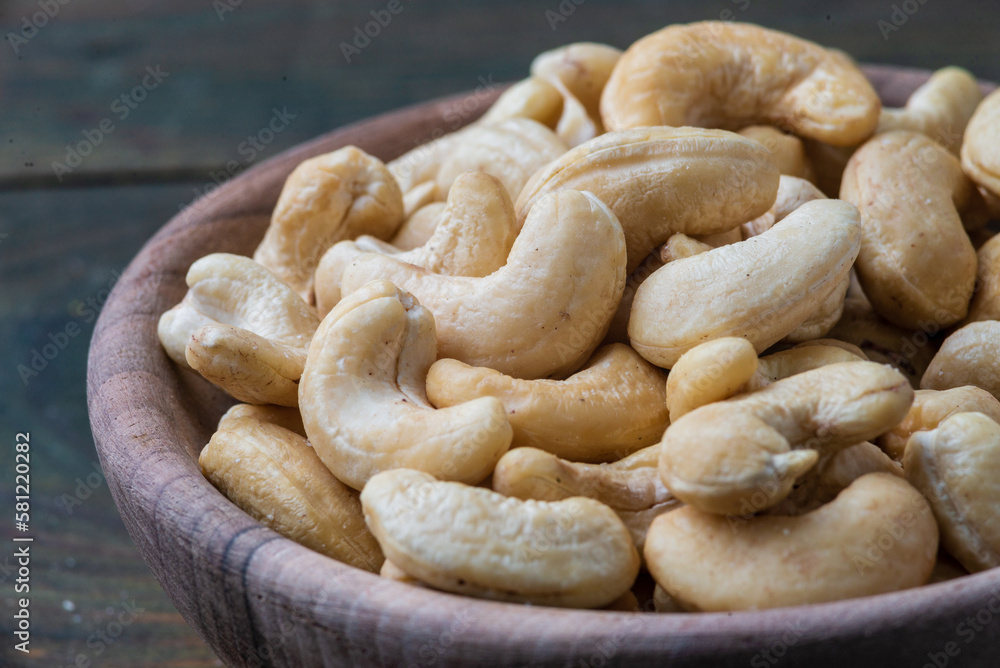 Bowl with raw cashew organic nuts peeled on wooden table rustic table, healthy vegetarian vegan snack Indian walnut Anacardium occidentale sackcloth close-up. Bowl with raw cashew organic nuts peeled on wooden table rustic table, healthy vegetarian vegan snack Indian walnut Anacardium occidentale sackcloth close-up.