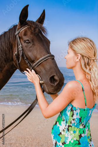 Happy pregnant woman with a horse on the beach in the summer on the nature