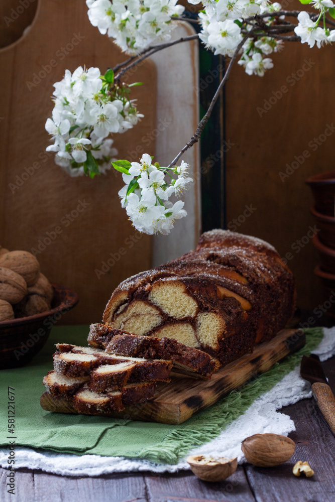 Traditional Easter bread with chocolate and nut filling on a wooden background.
