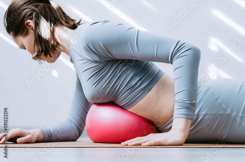 Woman doing breathing exercises with soft pilates ball