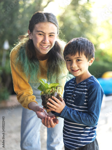 Smiling girl and boy planting vegetables in the garden