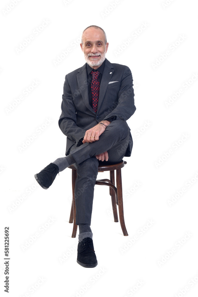 front view of a man sitting on chair with suit and tie and cross legged and looking at camera on white background front view of a man sitting on chair with suit and tie and cross legged and looking at camera on white background