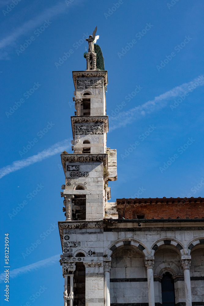Church front in Lucca, Italy, with blue sky and plane trails
