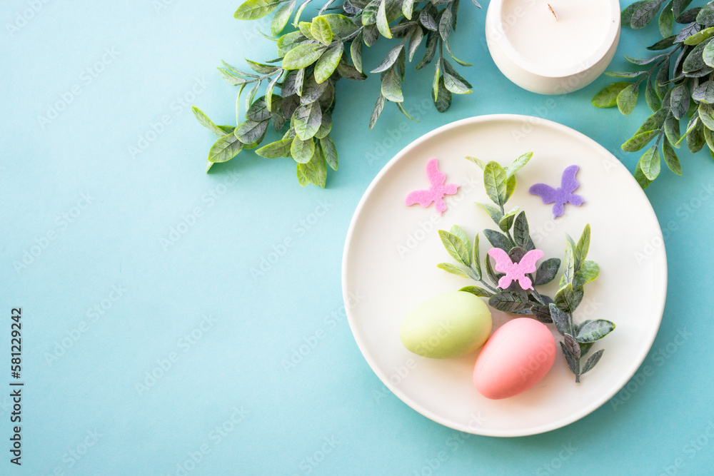 Easter table setting, Easter food background. White plate with eggs and holiday decorations. Top view with copy space.