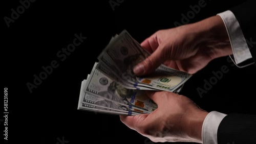 a man counts money on a black background