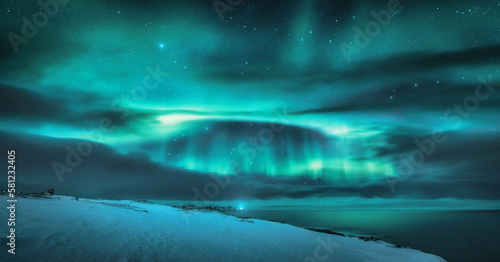 Aurora borealis over ocean. Northern lights and frozen sea coast
