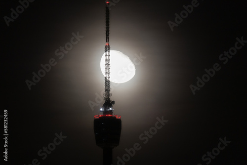 Fényképezés Full,  waning moon behind silhouette of the Stuttgart TV Tower