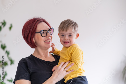 portrait of happy smiling mother and child living with down syndrome having fun. family moments photo