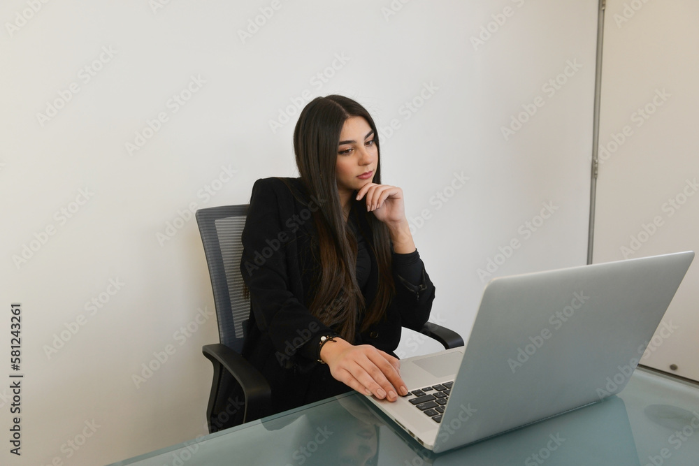 Happy woman working on her laptop at the office Happy woman working on her laptop at the office