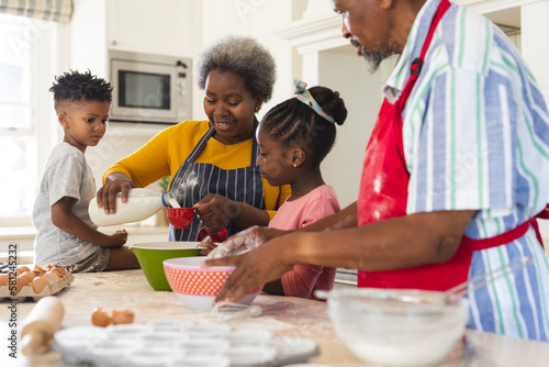 Happy african american grandparents and grandchildren baking together in kitchen