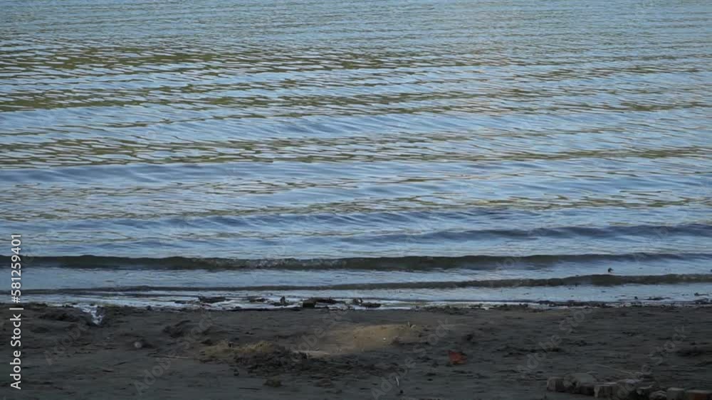 The tide. Beach on the sea or river. Water comes to sand. Waves on the water The tide. Beach on the sea or river. Water comes to sand. Waves on the water