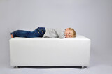 criança feliz sonhando deitada confortavelmente em sofá descansando 