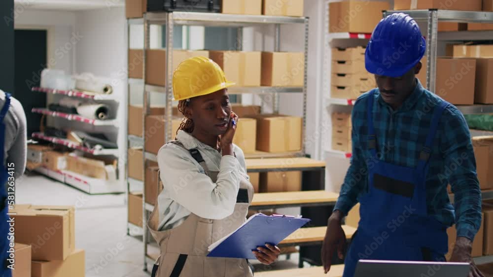 Warehouse employees planning shipment on laptop, working in storage room depot with merchandise in boxes. African american people checking stock logistics for business distribution. Warehouse employees planning shipment on laptop, working in storage room depot with merchandise in boxes. African american people checking stock logistics for business distribution.