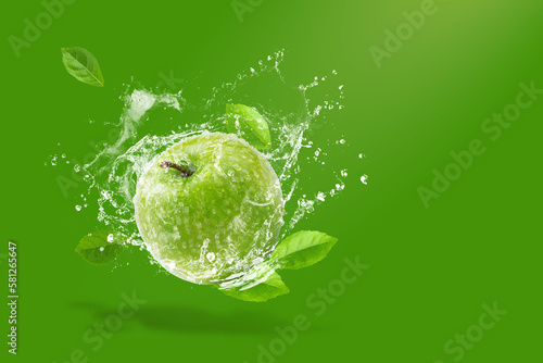 Water splashing on Fresh green apple on Green background