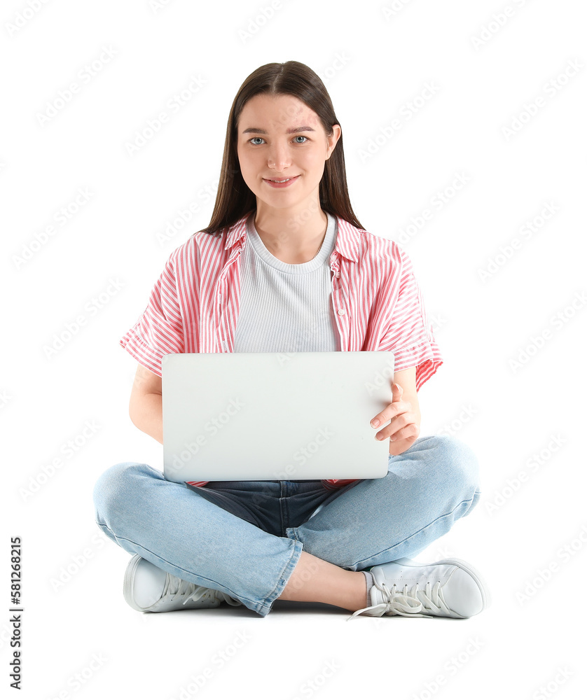 Naklejka premium Sitting young woman with laptop isolated on white