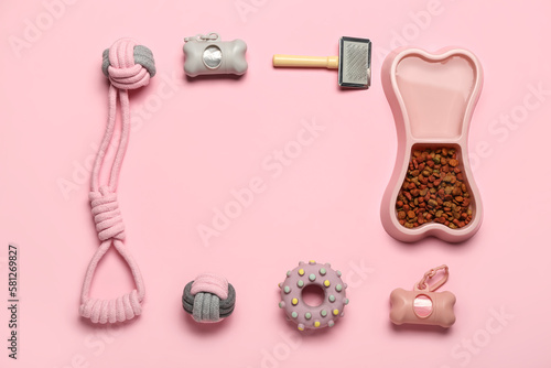Frame made of pet care accessories and dry food on pink background