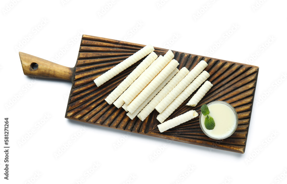Board with delicious wafer rolls, bowl of condensed milk and mint isolated on white background Board with delicious wafer rolls, bowl of condensed milk and mint isolated on white background