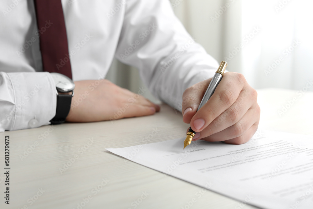 Notary signing document at wooden table indoors, closeup Notary signing document at wooden table indoors, closeup