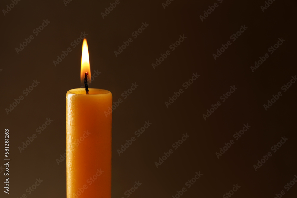 Burning church wax candle on dark background, closeup. Space for text Burning church wax candle on dark background, closeup. Space for text