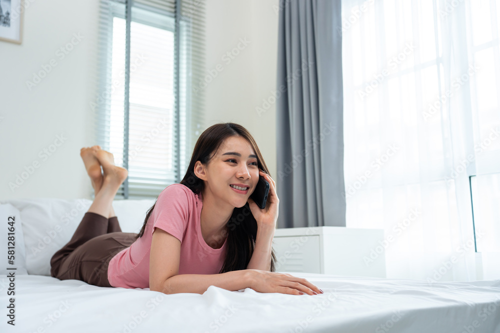 Asian attractive woman use mobile phone chat on bed at home in morning. Asian attractive woman use mobile phone chat on bed at home in morning.