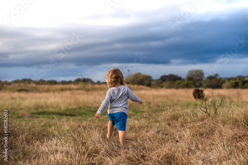 Toddler running through farmland