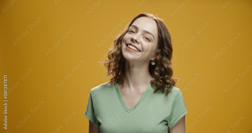 Happy young woman looking at camera. Portrait of comfortable woman in casual clothes. Portrait of beautiful girl smiling and relaxing during. isolated yellow background Happy young woman looking at camera. Portrait of comfortable woman in casual clothes. Portrait of beautiful girl smiling and relaxing during. isolated yellow background